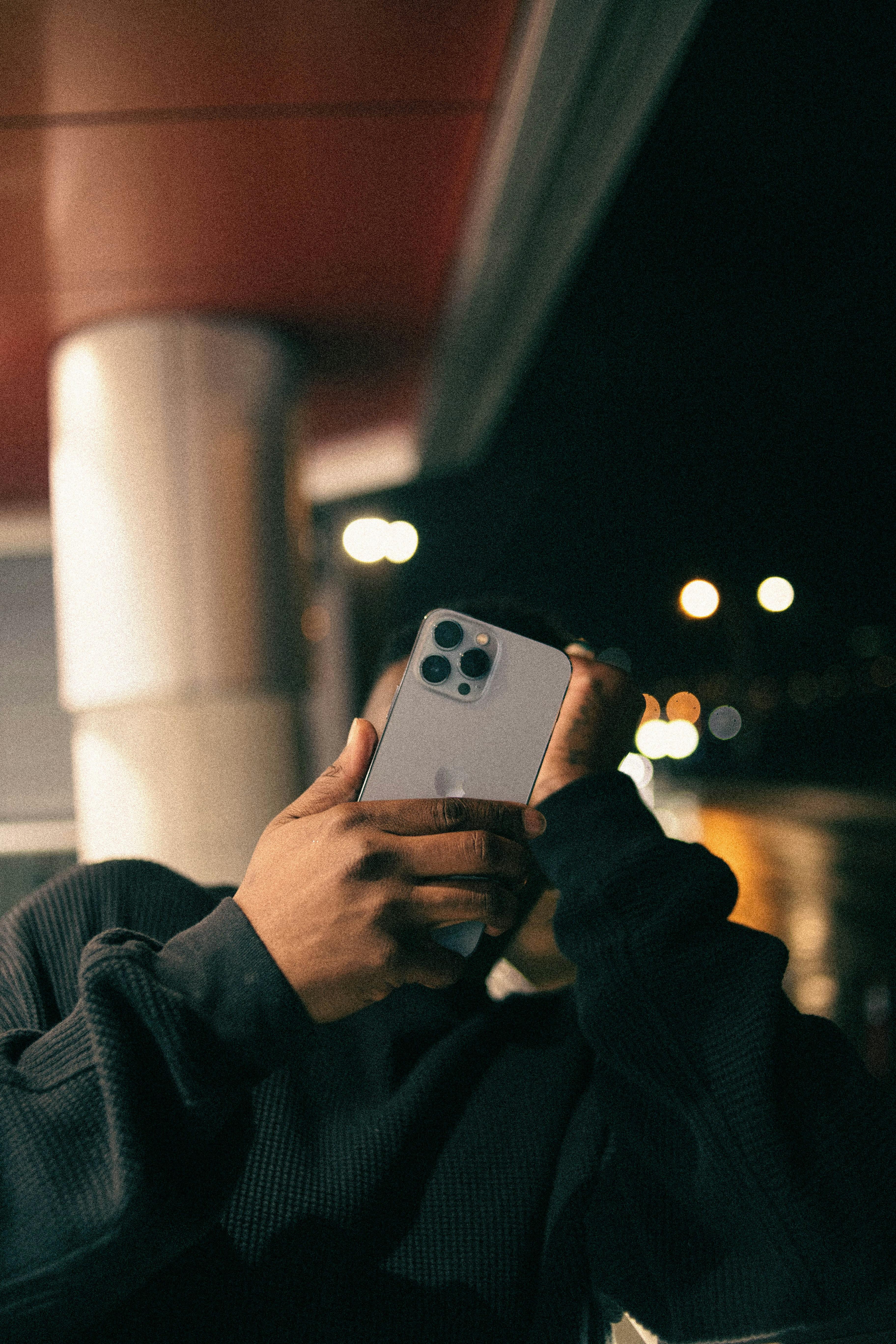 iPhone in hand covering man's face