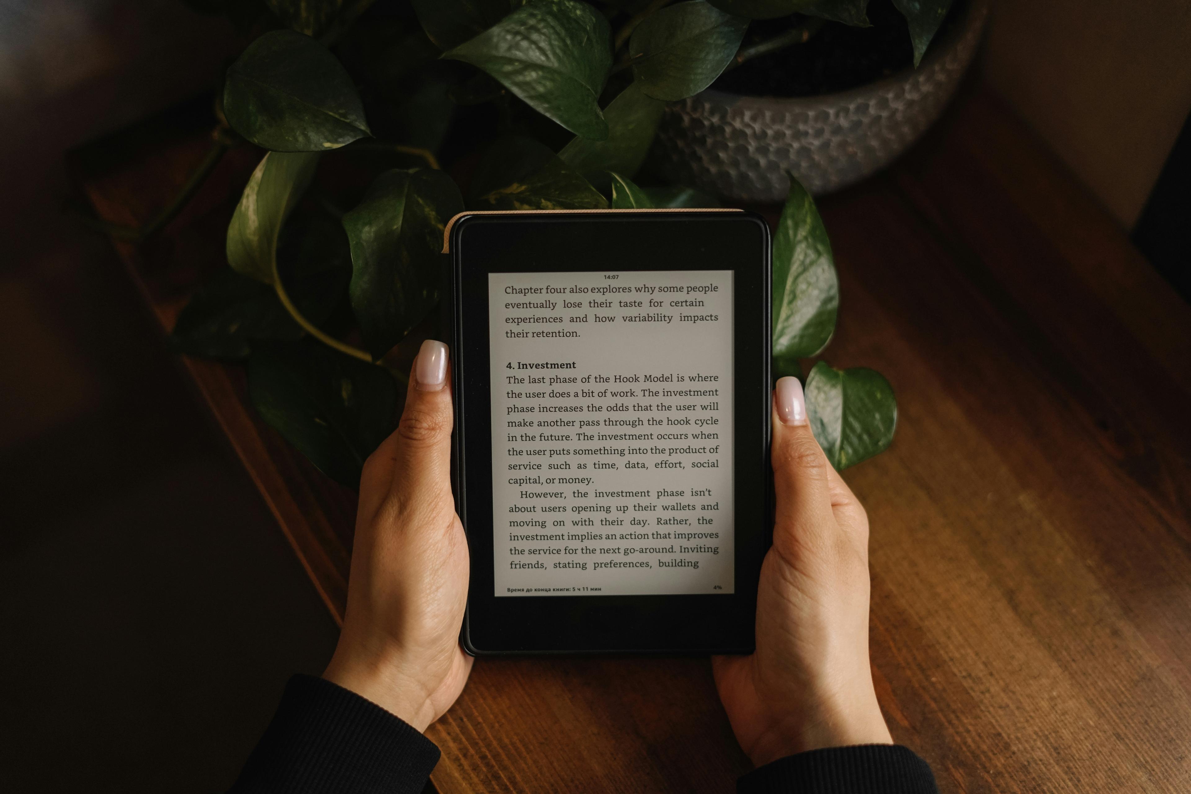 Hands holding Amazon Kindle e-reader